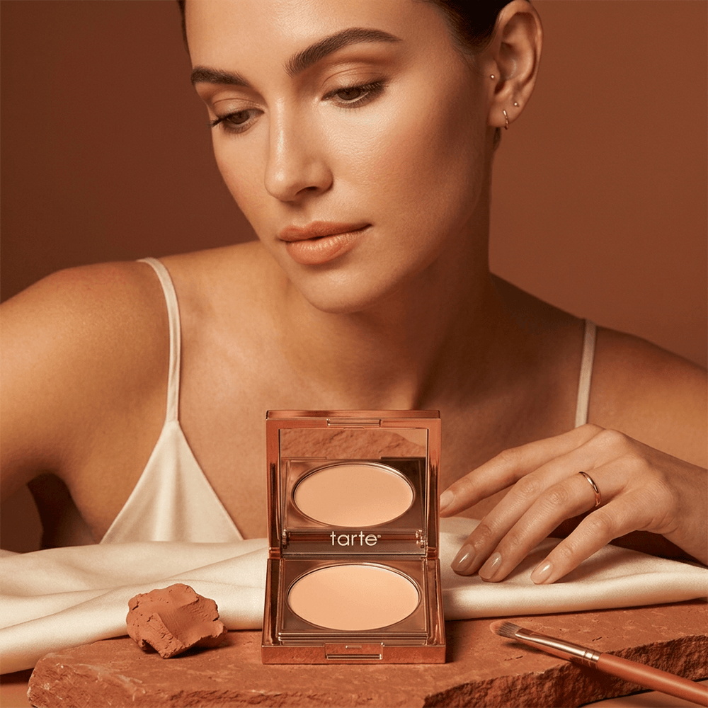 Tarte Under Eye Corrector with Brush – Full Coverage Concealer displayed with model applying makeup, showcasing its brightening effect.